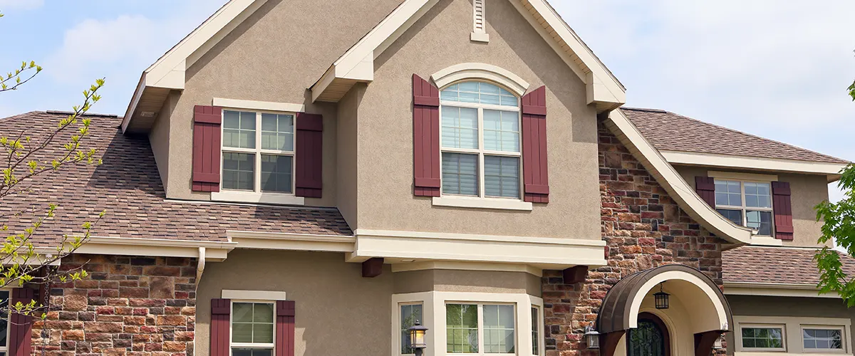 home exterior with brick and red window shutters