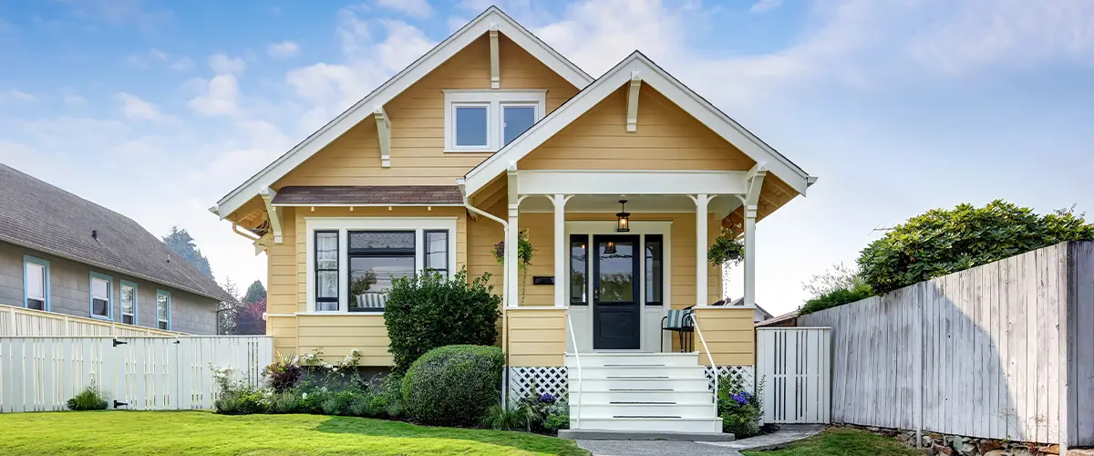 American craftsman home with yellow exterior paint.