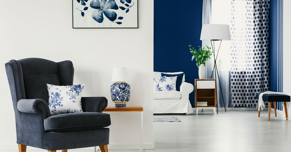 Modern living room with navy and white decor, featuring accent wall, stylish furniture, and elegant interior design.